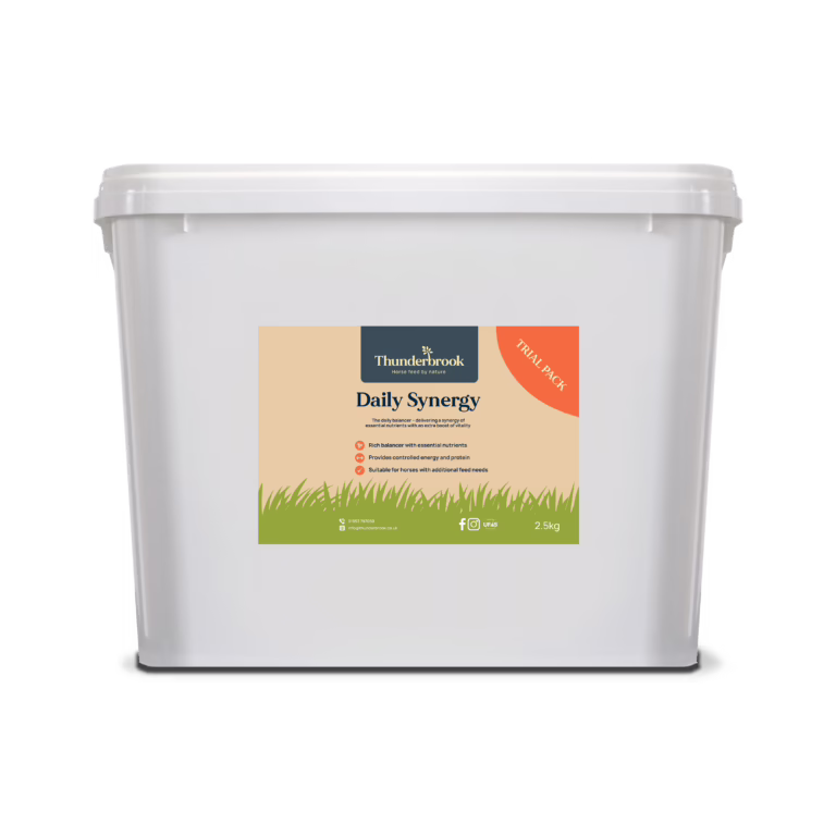 White plastic tub labeled Thunderbrook Daily Synergy horse feed, with beige and navy label and an orange 'Trial Pack' badge on a grass graphic background.